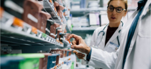Pharmacy worker looking at medicine on a shelf