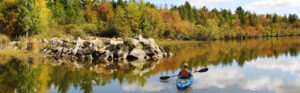 NACPRO member canoeing on river in fall