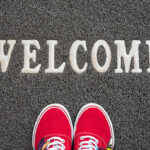 
                            A pair of shoes on a welcome mat, representing a member welcome letter.                            