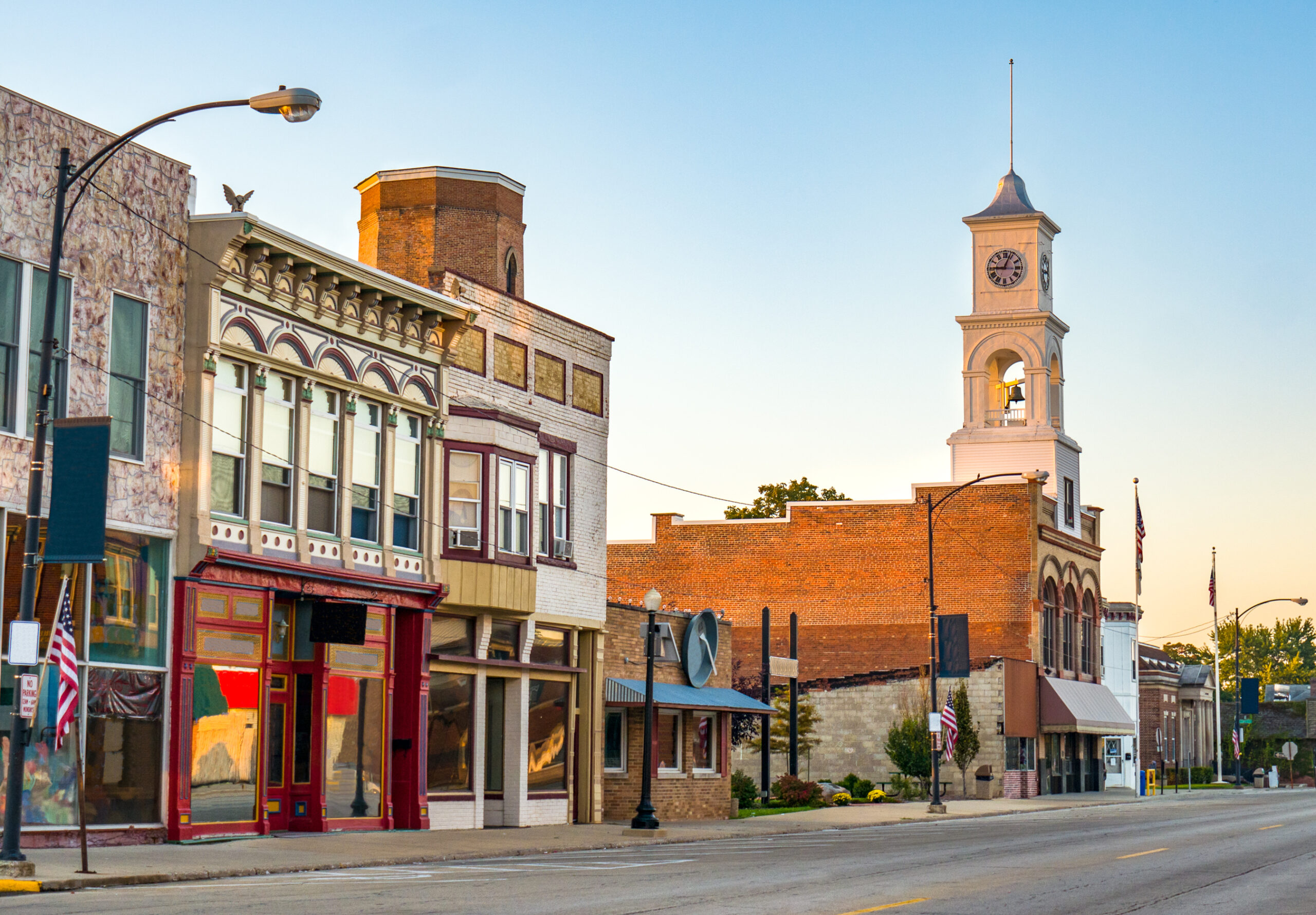 A small town street with storefronts that are a part of a chamber of commerce.