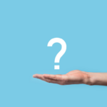 
                            A person extends their hand palm up and holds a question mark against a light blue background, reflecting their curiosity about association management software.                            