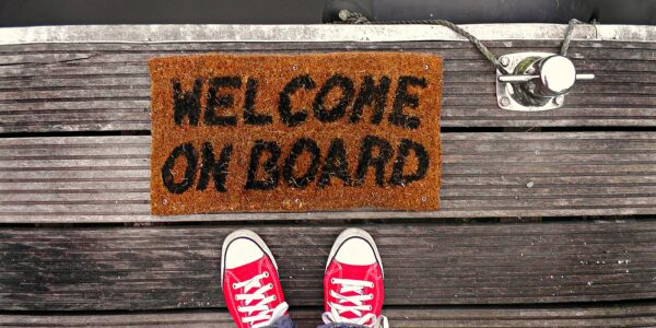 A pair of shoes on a welcome mat, welcoming a member who has completed an association membership form.