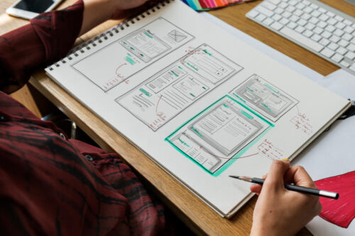 woman looking at website mockup on drawing paper