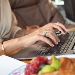 
                            woman writing content on a laptop for her association members                            