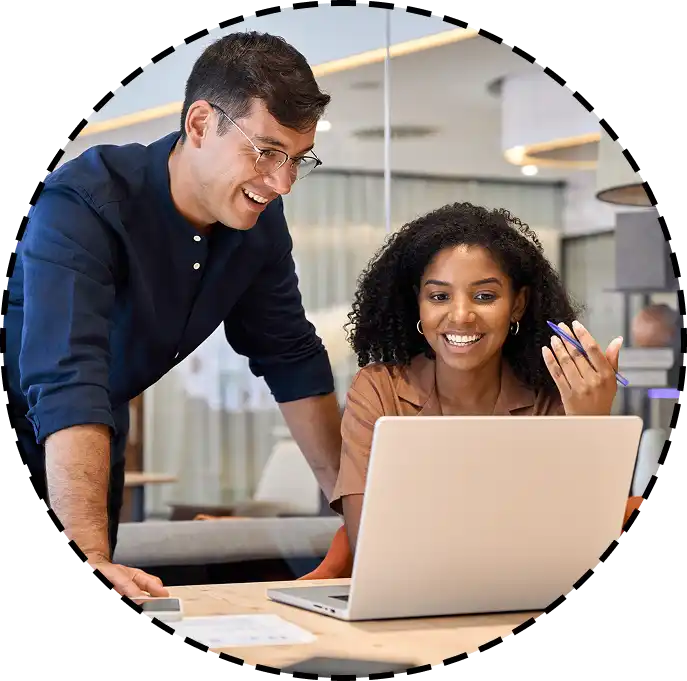 coworkers laughing while looking at laptop