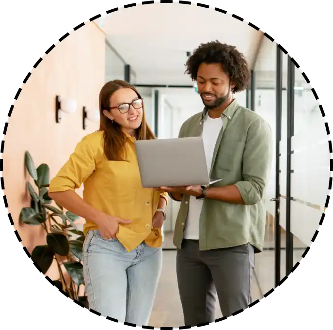coworkers look at a laptop together