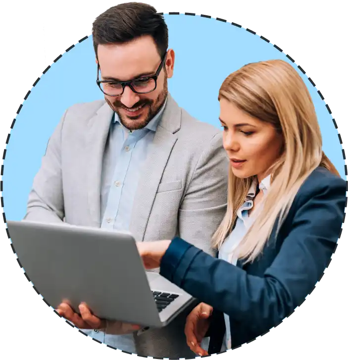 a man and a woman pointing at a laptop screen