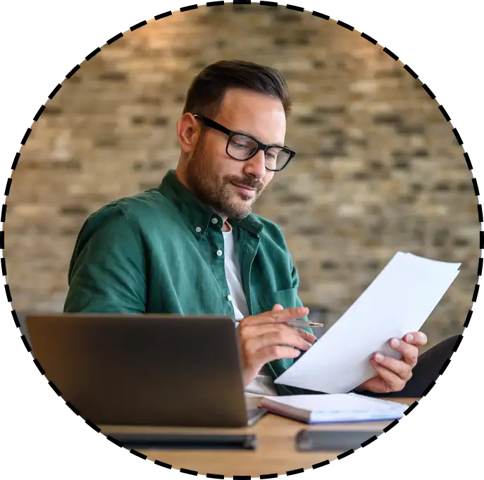 man holding a pen and reading a document