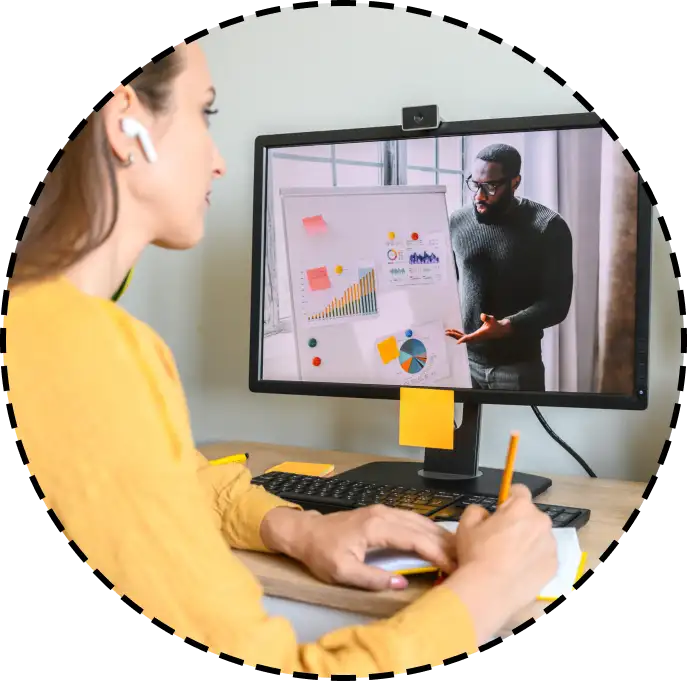 student watches a course on a screen while taking notes