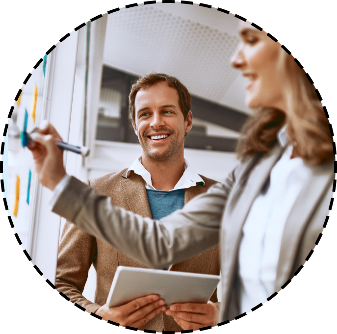 colleagues smile while brainstorming on a white board