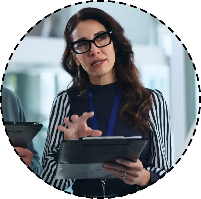 a woman speaks while holding a tablet computer