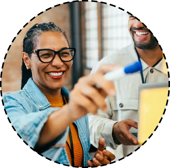 a woman writes with a dry erase marker during a meeting